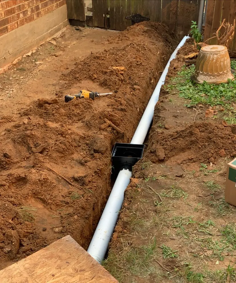 PVC pipe and catch basin being installed for a French drain system, Bedford, Tx